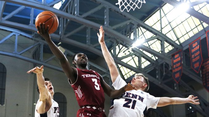 Junior guard Shizz Alston Jr. (center) attempts a layup over Penn sophomore forward AJ Brodeur (left) and sophomore guard Ryan Betley during the Owls’ 60-51 win against the Quakers on Saturday at The Palestra. | EVAN EASTERLING / THE TEMPLE NEWS