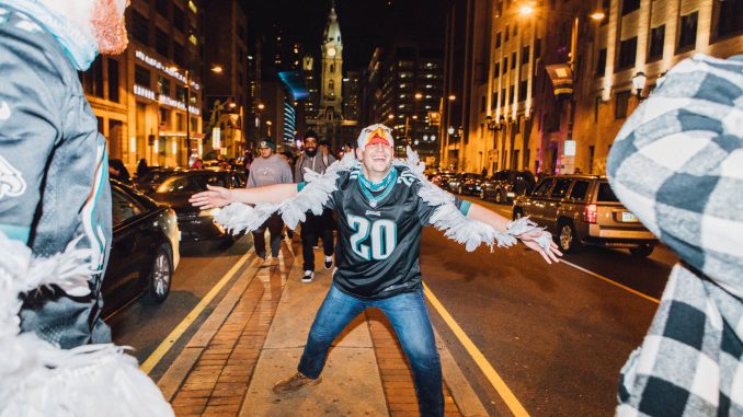 An Eagles fan celebrates on the median of Broad Street, flapping his arms like wings, after the Eagles won the NFC Championship to advance to the Super Bowl on Sunday. | SYDNEY SCHAEFER / THE TEMPLE NEWS