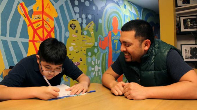 Youth Coordinator James Owk helps Alain Nguyen do his homework at the Mighty Writers center on Oct. 25. | URSZULA PRUCHNIEWSKA / TTN