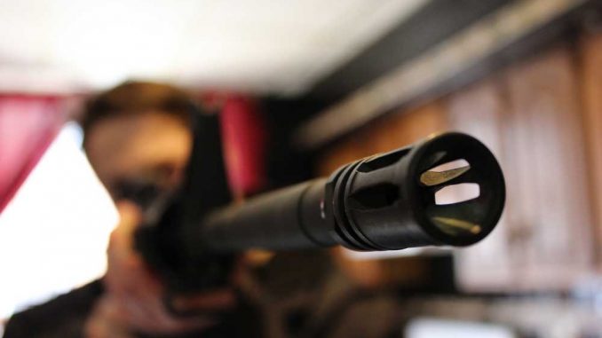 Senior Mark Edwards displays a firearm in his off-campus apartment. | ELLEN PARKINS / TTN