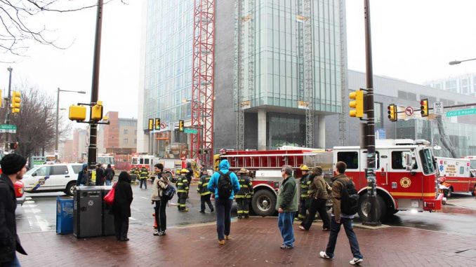 Bystanders look on as firefighters contain a fire on the 18th floor of Morgan Hall. The $216 million, 27-story residence hall apparently received little damage from the fire. | ANGELO FICHERA / TTN