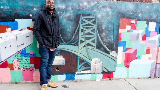 Donnell Powell stands next to a mural commissioned through his first nonprofit. | LUIS FERNANDO RODRIGUEZ / TTN