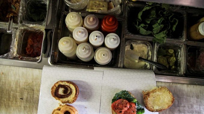 Burger Busz food assembly line displays a line of condiments during construction of a burger. Owner Juno Park said burgers are his most popular item. | Timothy Valshtein TTN