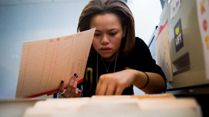 Chloe Brown, a sophomore criminal justice major, searches for the file of a client she is assisting with their job search at LIFT North Philadelphia. | Abi Reimold TTN