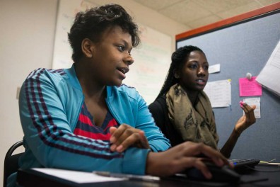 Michelle Samys (left) attends her fourth visit to LIFT North Philadelphia. Temple student DiAsia Dozier is helping her work on her college applications, including writing and filling out forms. | Abi Reimold TTN