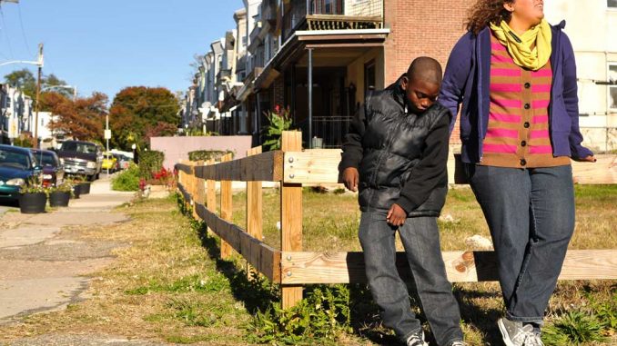 Emaleigh Doley (right) and Kevon Lewis stand in front of an empty lot on West Rockland Street that she and her sister Ainé helped improve in 2008. | JACOB COLON TTN