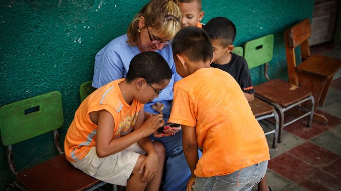 Suzanne Durocher works with children in Honduras this past summer as part of a clinical tour. | COURTESY LINA KHONG