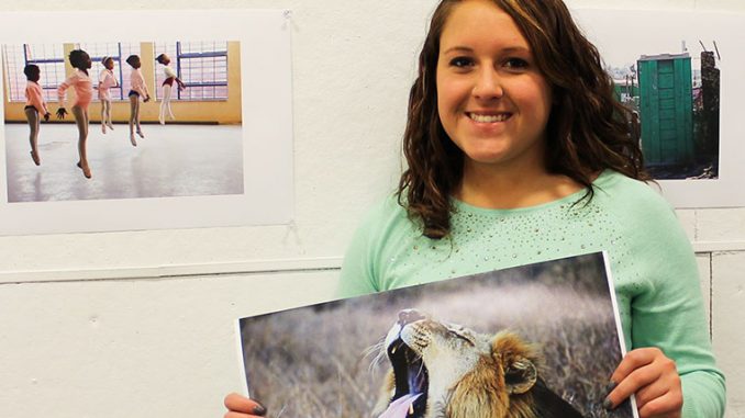 Kelsey Dubinsky holds the photo she took in South Africa of a wild lion mid-yawn in Kruger National Park of South Africa. | Sash Schaeffer TTN