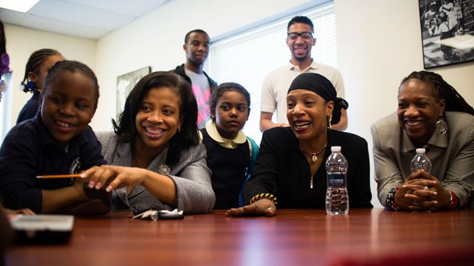 Bishop Mary Palmer (second from left) attended the Crayons for Haiti fundraiser presentation at Women’s Christian Alliance on April 8 to hear children present about their donation efforts. Palmer said she spends around 30 hours at WCA every week to boost morale. | ABI REIMOLD TTN