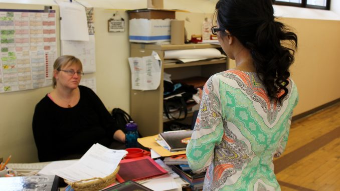 Senior Jennifer Nguyen (right) talks with local teacher Christine Swift as part of a high school journalism workshop. | Claire Sasko TTN