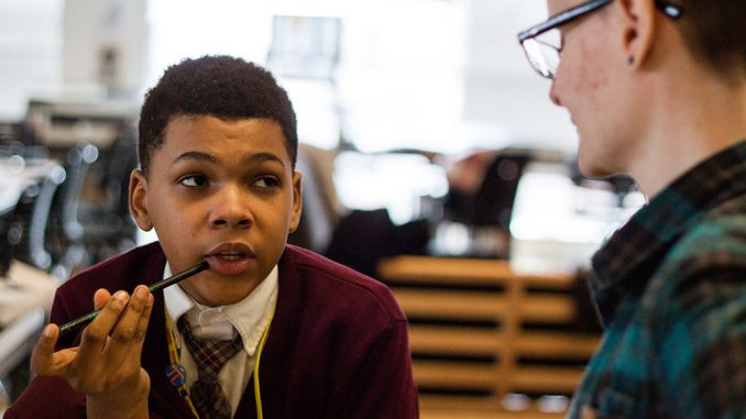 A student at St. James School works with a graphic design student from Tyler School of Art. As part of the graduate program’s thesis project this semester, instructor Kelly Holohan arranged the partnership between the local middle school and graduate students. | Kara Milstein TTN