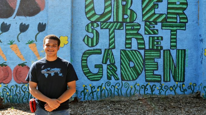 Engineers Without Borders Project leader Torin Johnson stands in front of the Uber Street Garden Mural on Sept. 27. Jenny Kerrigan TTN