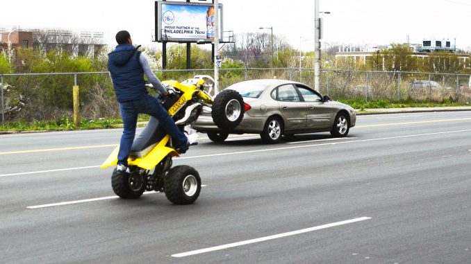 An ATV driver rides down Grays Ferry Avenue in 2012, while performing a wheelie. Andrew Thayer |TTN