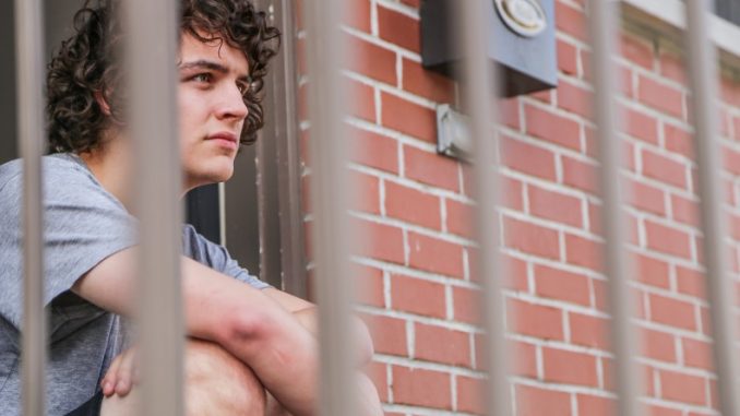 Junior film and media arts major Billy Denham sits outside his front door on the 1900 block of 18th Street. On Sunday, two armed men allegedly tied up his roommates and fled with cash and electronics. Denham said he was not home for the incident. Andrew Thayer | TTN