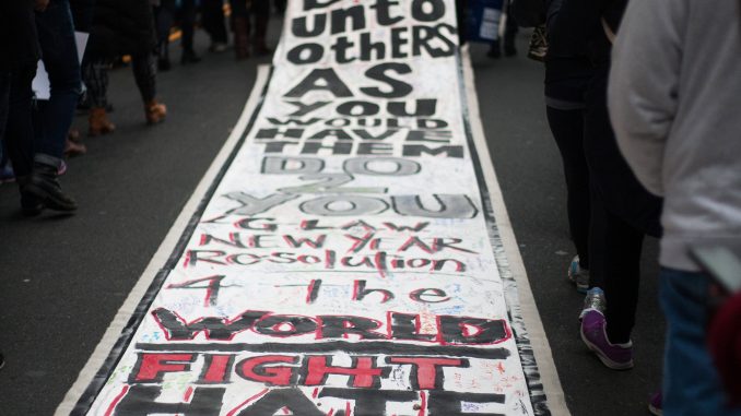 Marchers hold signs as they walk down Broad Street as part of a rally on Martin Luther King Jr. Day. | Skyler Burkhart TTN