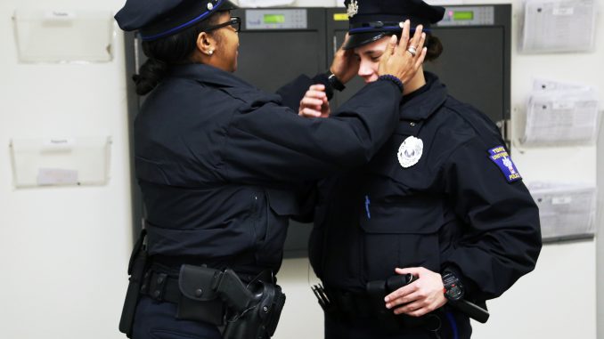 Officer Sherrelle Mitchell adjusts the hat of her colleague, Officer Melissa Tracton. Jenny Kerrigan | TTN