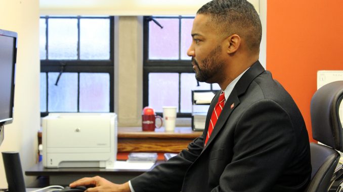 Senior Vice President for Government, Community and Public Affairs Ken Lawrence uses the computer in his office. | Alex Beaufort TTN