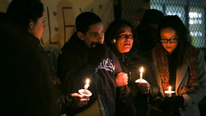 Alex Rojas-Garcia’s sister Aleida Silva-Garcia (left), son Alex Jr., sister Enid Rojas and daughter Brianna hold candles at a vigil for him in Feltonville on Feb. 7. | JENNY KERRIGAN TTN