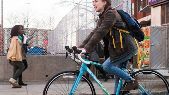 Lily Goldberg rides her bicycle on Montgomery Avenue to raise money for affordable housing. Goldberg and Dustin Miller will ride their bikes from Charleston, South Carolina to Santa Cruz, California. | Allan Barnes TTN