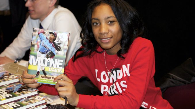 Mo’ne Davis holds a signed copy of her book, titled “Mo’ne Davis: Remember my Name: From First Pitch to Game Changer.” | COURTESY TFisherphotography