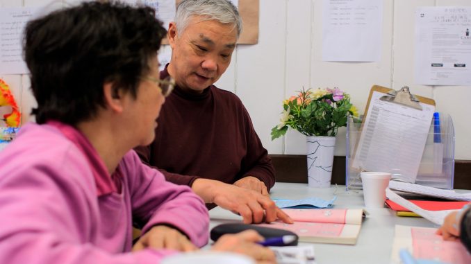 Muoi Thai, 68 (left), and Jiang Bogun, 65, practice English at the Coffee Cup Branch of the Philadelphia Senior Center on March 19. The two are students in the IGC’s Project SHINE program. | Harrison Brink TTN