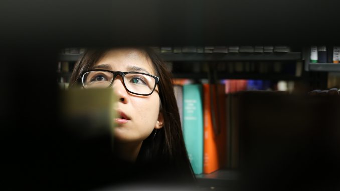 Angkeakeo Hak, a senior English major, looks for a book in Paley Library on March 19. | Jenny Kerrigan TTN