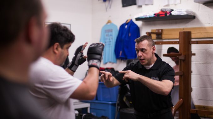 Allen Chambers, Temple alumnus and owner of Philadelphia Self Defense in Old Kensington, instructs students while they warm up before class. | Margo Reed TTN