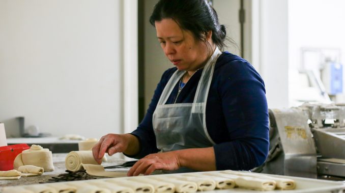 Amanda Eap rolls dough used to make authentic croissants, Artisan Boulanger Patissier’s speciality. | Eamon Dreisback TTN