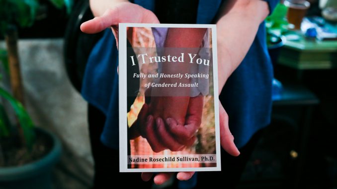 Professor Rev. Dr. Nadine Rosechild Sullivan holds her book, “I Trusted You”, which discusses violence against women. | Jenny Kerrigan TTN