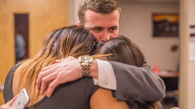 Ryan Rinaldi (center) hugs Brittany Boston (left) and Binh Nguyen after learning the result of the Temple Student Government election, which was announced Thursday. The three will take office on April 27. | Margo Reed TTN