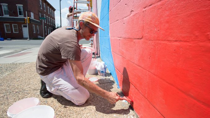 Mural artist MOMO paints for Open Source, a projected created by Mural Arts in Philadelphia. | COURTESY Mural Arts Program