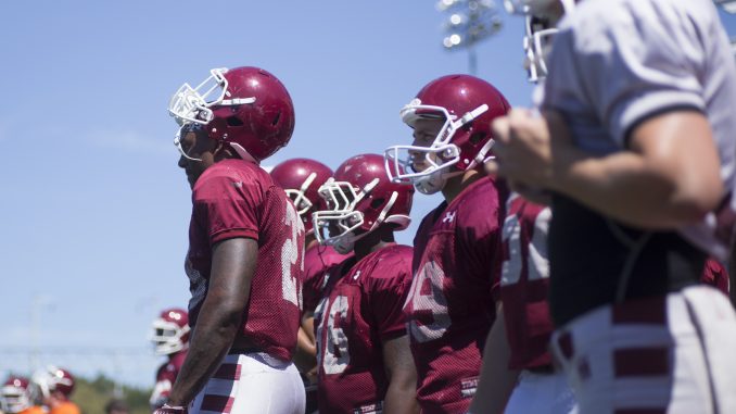 The football team stands on the sideline during a practice at Chodoff Field. | Margo Reed TTN