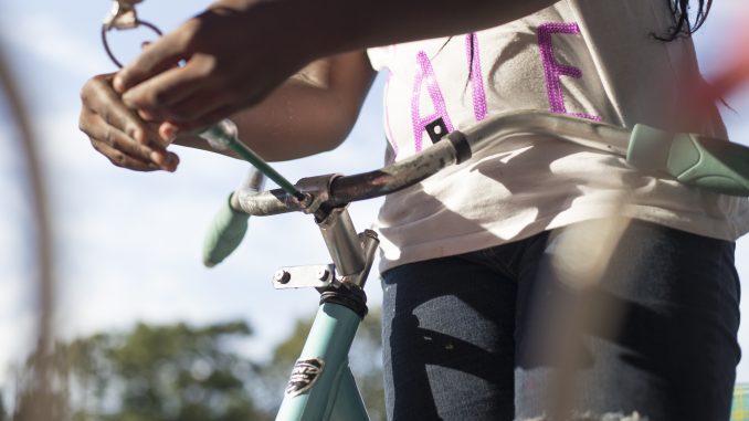 Dashetta Davenport, of Norris Street, fixes her bike at a bike repair station near Paley Library on Aug. 18. | Margo Reed TTN