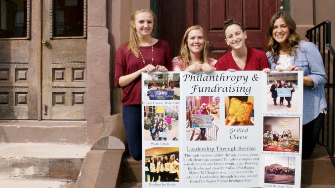 Rachel Makar (left), Mackenzie Blue, Lauren Ravitch and Tori Cuccurullo display a poster detailing Phi Sigma Sigma’s philanthropy events for Oct. 5-8. | Joshua Dicker TTN