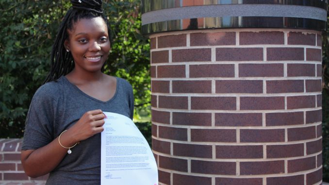 Indonesia Young, a freshman English major, holds the letter notifying her of winning the Katz Scholarship beside the Red Owl Statue at Alumni Circle on Main Campus. | Matt McGraw TTN