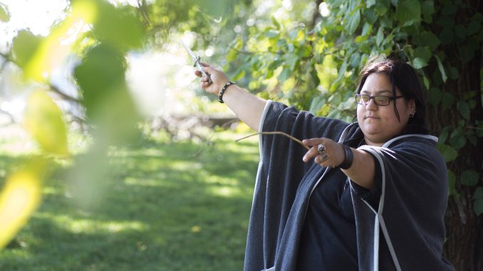 Jessica Castro, a practicing Wiccan, uses an athame and wand to channel energy in nature. | Margo Reed TTN