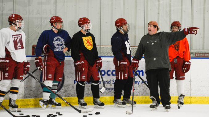 Coach Roman Bussetti (second from right) addresses the ice hockey team during a recent practice. | Brianna Spause TTN