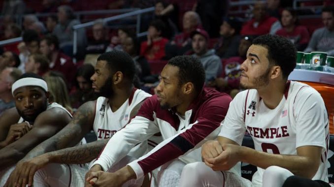 Sophomore forward Obi Enechionyia (right,) sits next to his teammates on the bench during the second half of the Owls' 77-50 loss to Houston Saturday | Jenny Kerrigan