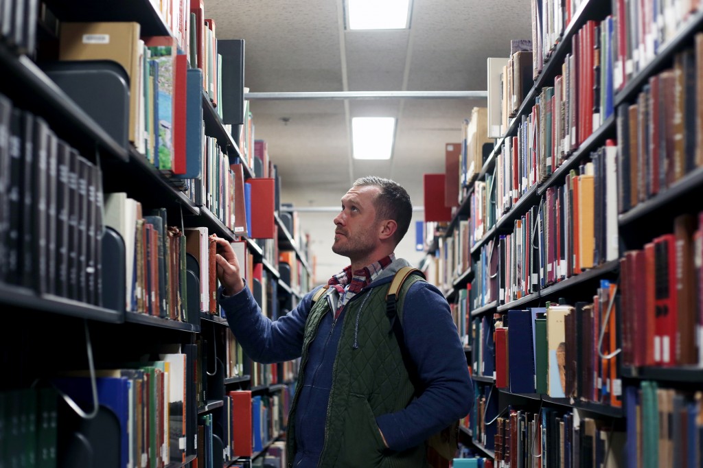 Brian Korn, a 29-year-old senior majoring in German, peruses the aisles of the library. He said reading was a large part of his recovery.